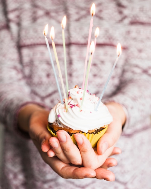 Hands holding birthday muffin