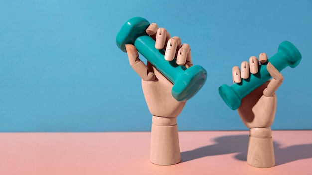 Free photo hands holding blue dumbbells still life