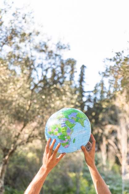 Free photo hands holding blue planet model