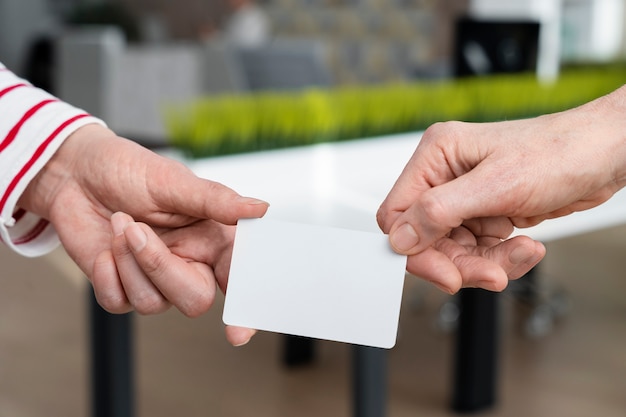 Hands holding business card high angle