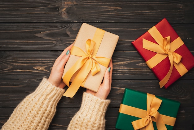 Free Photo hands holding christmas gift with golden ribbon