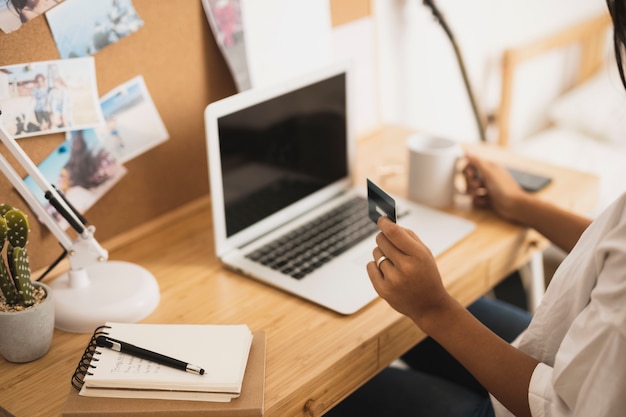 Hands holding a credit card and a coffee mug