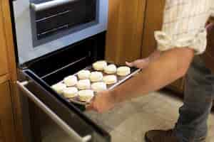 Free photo hands holding dough tray scone bakery concept