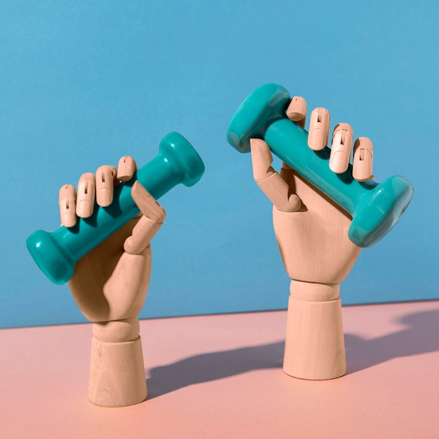 Free Photo hands holding dumbbells still life