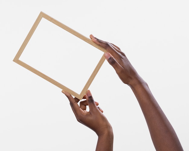 Free photo hands holding frame with white background