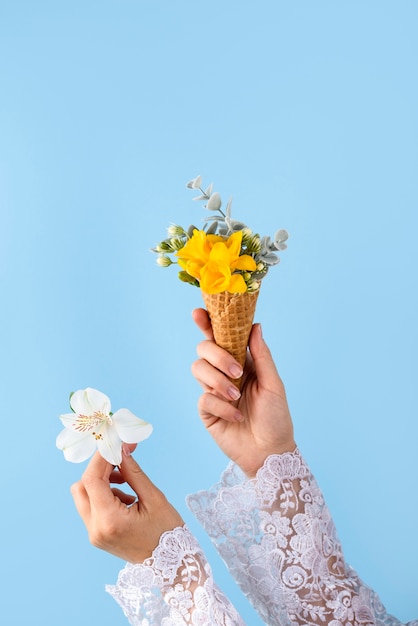 Hands holding ice cream cone and flower