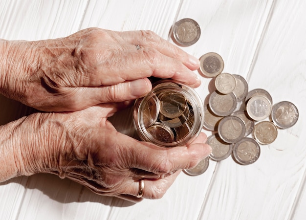 Hands holding a jar filled with coins