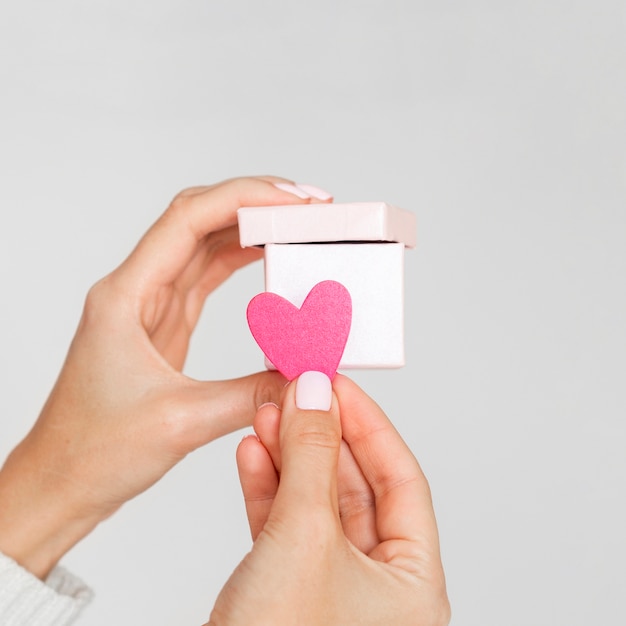 Free photo hands holding paper heart and box