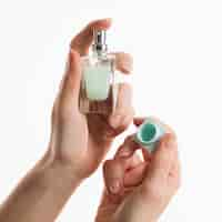 Free photo hands holding perfume bottle