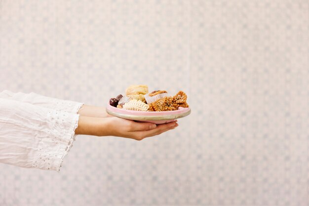 Hands holding plate of arab food