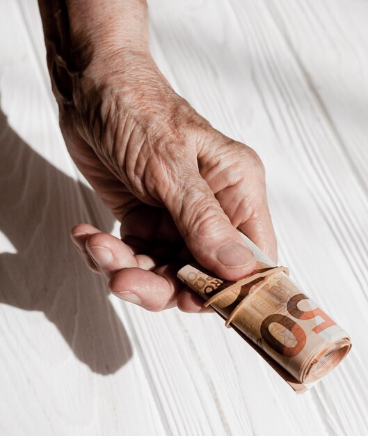 Hands holding a roll of banknotes