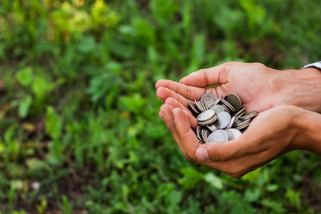 Free Photo hands holding saving coins outdoor