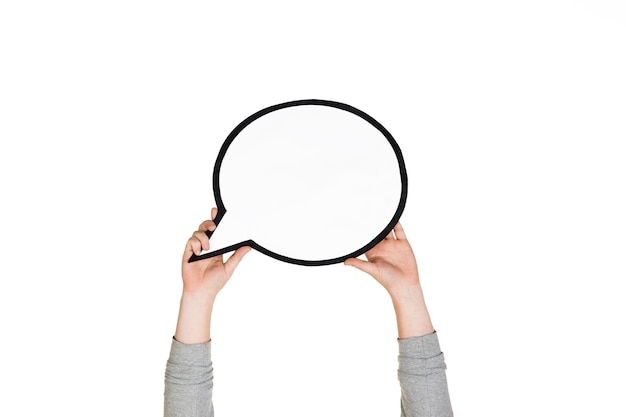 Hands holding the sign of comment on white studio background.