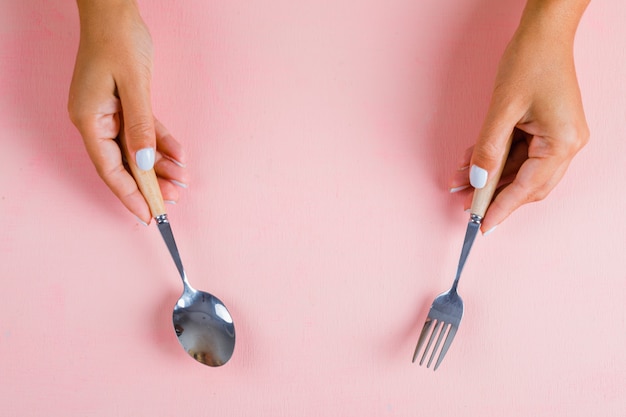 Hands holding spoon and fork