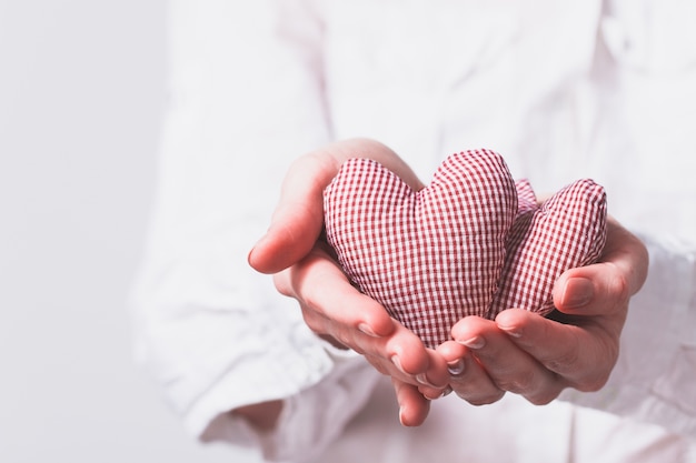 Free photo hands holding two teddy hearts