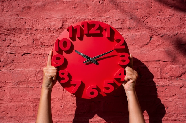 Hands holding wall clock still life