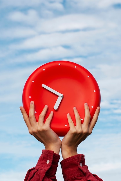 Hands holding wall clock still life