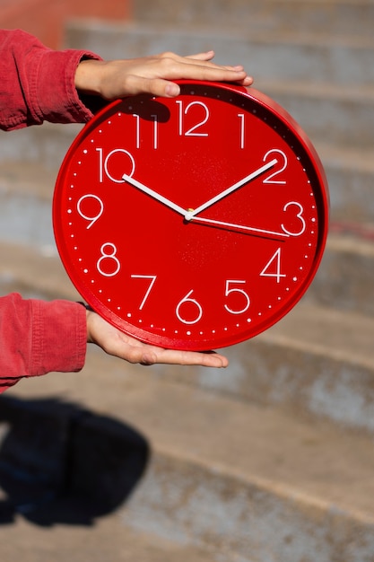 Hands holding wall clock still life