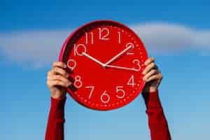 Free photo hands holding wall clock still life