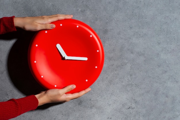 Hands holding wall clock still life