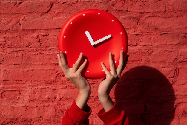 Free photo hands holding wall clock still life