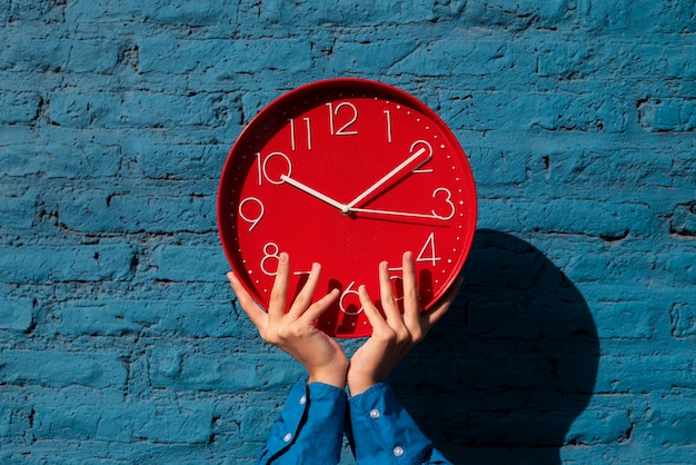 Hands holding wall clock still life