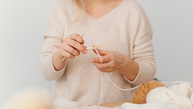 Hands knitting with white thread close-up