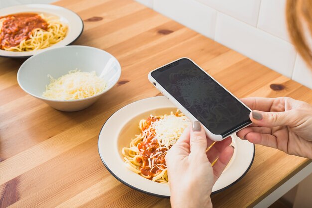 Hands making photo of food plate