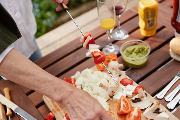 Hands making skewers high angle