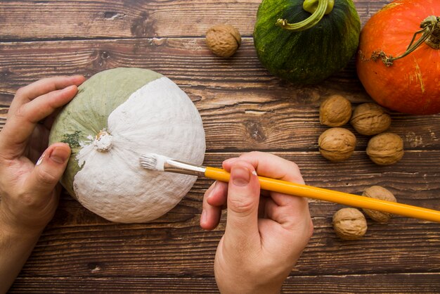 Hands painting pumpkin 