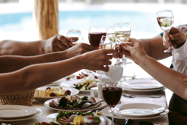 Hands of people with glasses of champagne or wine, celebrating and toasting in honor of the wedding or other celebration.