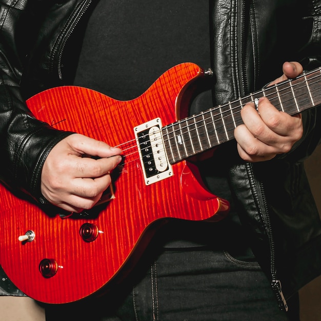 Free photo hands playing beautiful red guitar