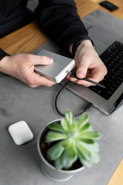 Hands plugging in ssd device high angle