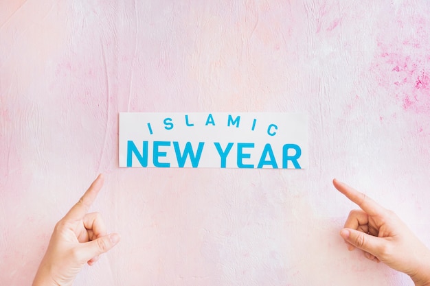 Hands pointing at Islamic New Year paper