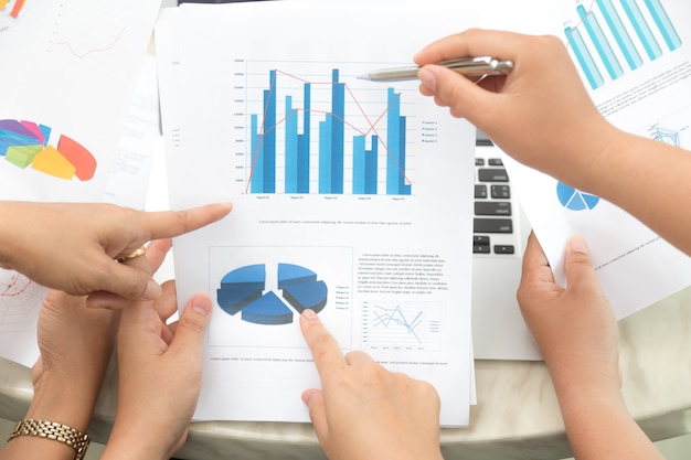 Free photo hands pointing to a statistical document