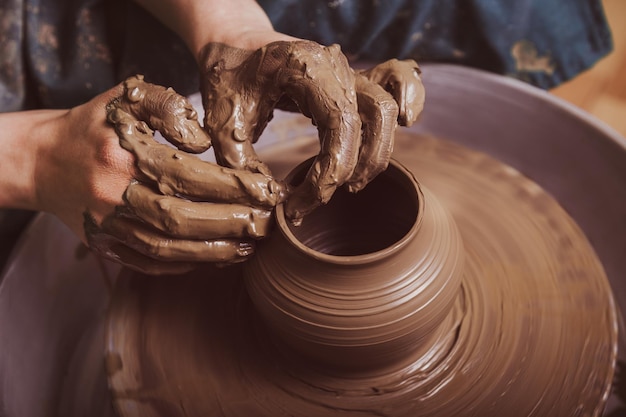 Hands of a potter, creating an earthen jar