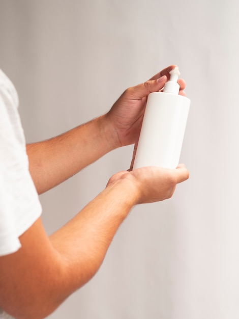 Hands presenting cream bottle mock-up 