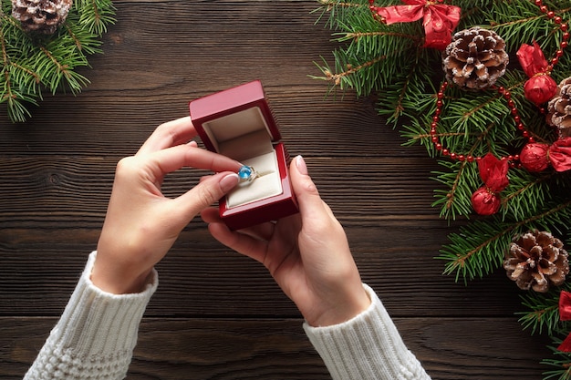 Hands putting a ring in a red box