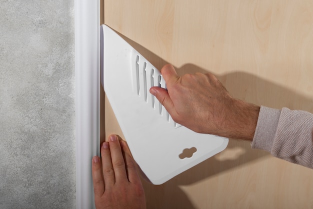 Hands putting up decorative vinyl with tool