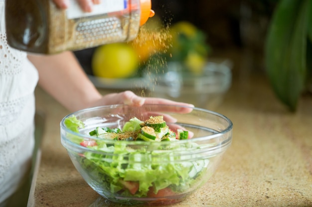 Free Photo hands spicing a green salad up