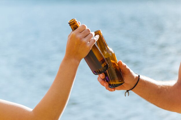 Hands toasting with bottles of beer