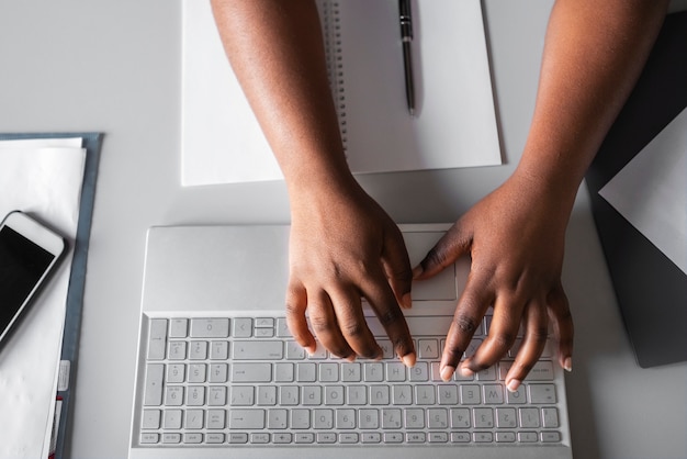 Hands typing on keyboard top view