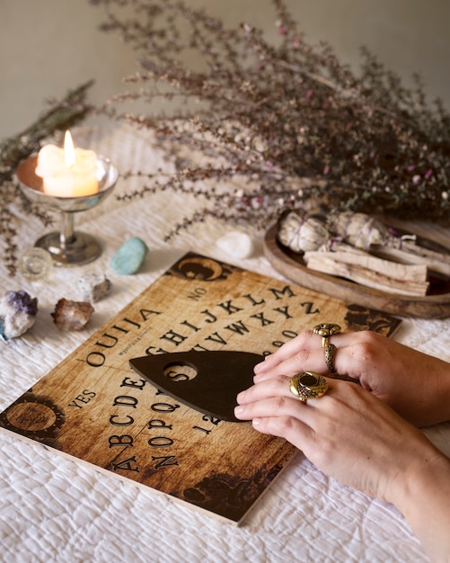 Hands using old wooden ouija board