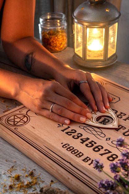 Free photo hands using ouija board high angle