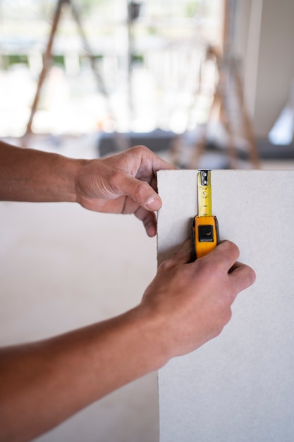 Hands using tape measuring tool