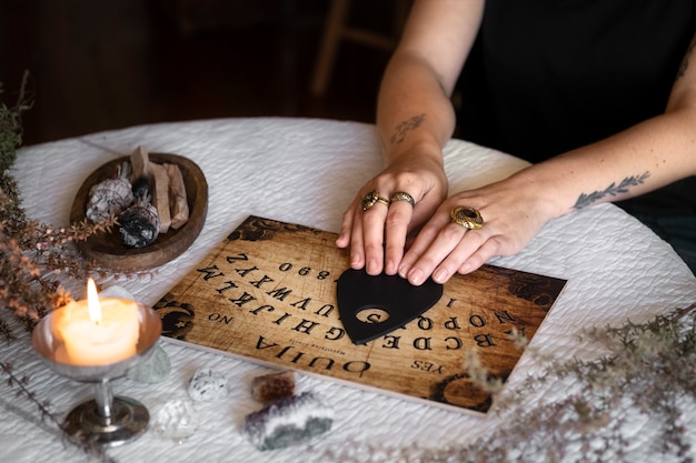 Free photo hands using wooden ouija board high angle