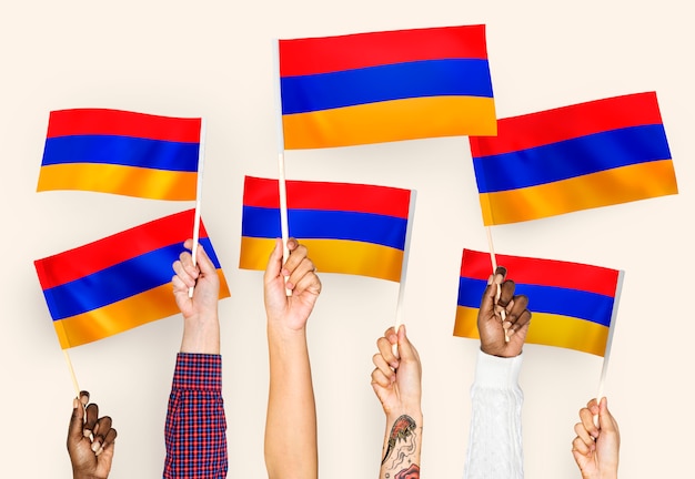 Free photo hands waving flags of armenia