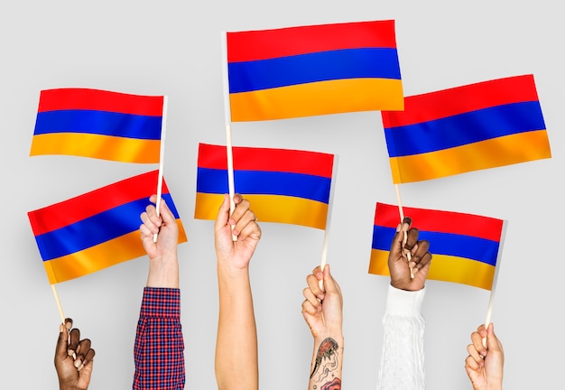 Free photo hands waving flags of armenia