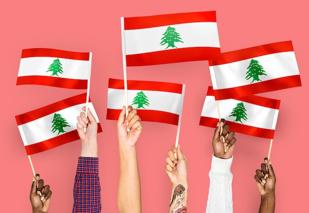 Free photo hands waving flags of lebanon