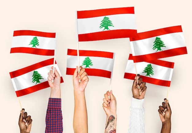 Free photo hands waving flags of lebanon